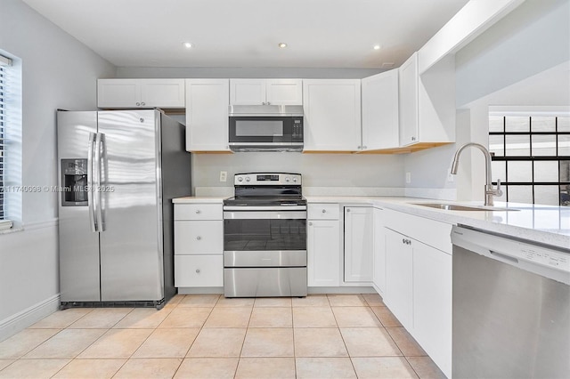 kitchen featuring light countertops, appliances with stainless steel finishes, a sink, and white cabinetry