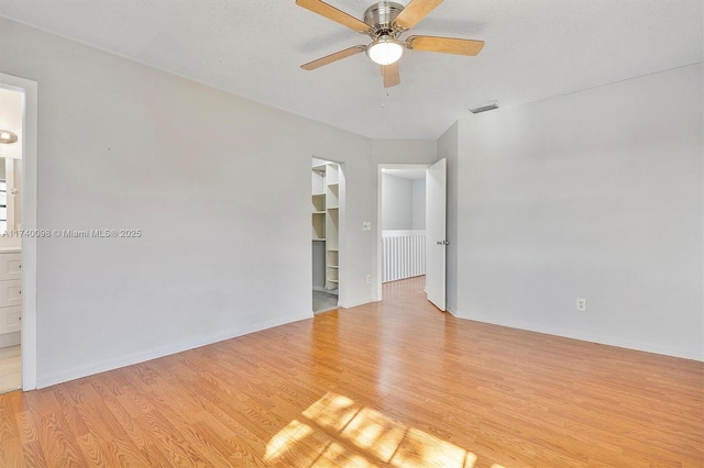 spare room with light wood-style floors, visible vents, and ceiling fan