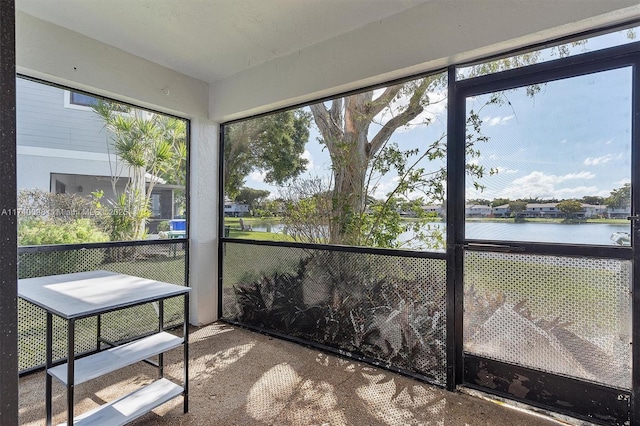 sunroom featuring a water view