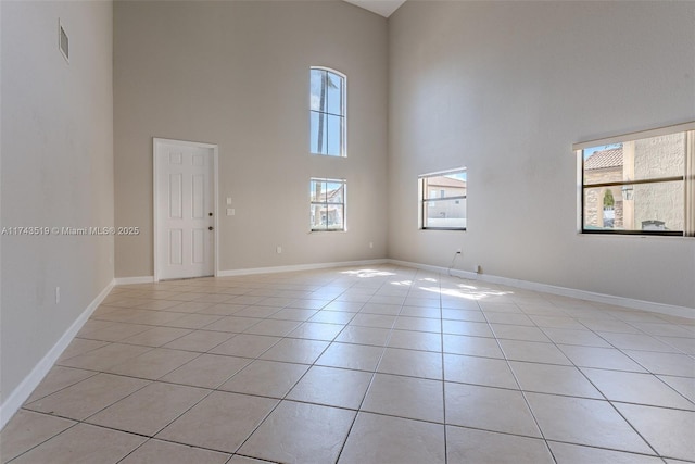 unfurnished room featuring a high ceiling and light tile patterned floors