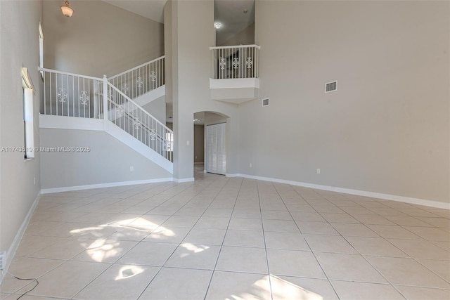 unfurnished living room featuring a high ceiling and light tile patterned floors