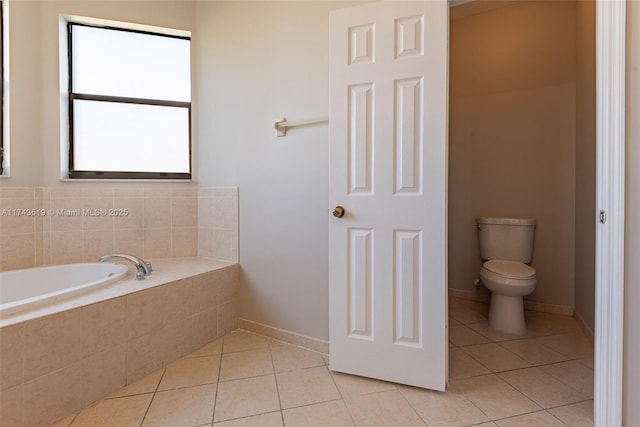 bathroom featuring tile patterned flooring, a relaxing tiled tub, and toilet