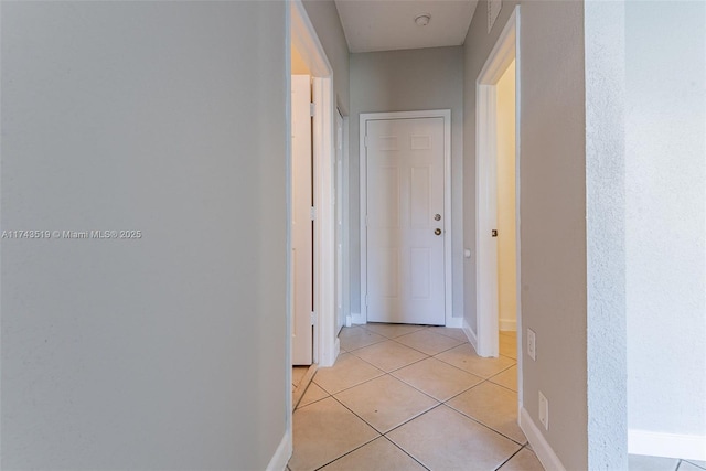 hall with light tile patterned floors