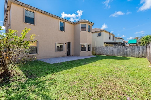 rear view of property featuring a yard and a patio area