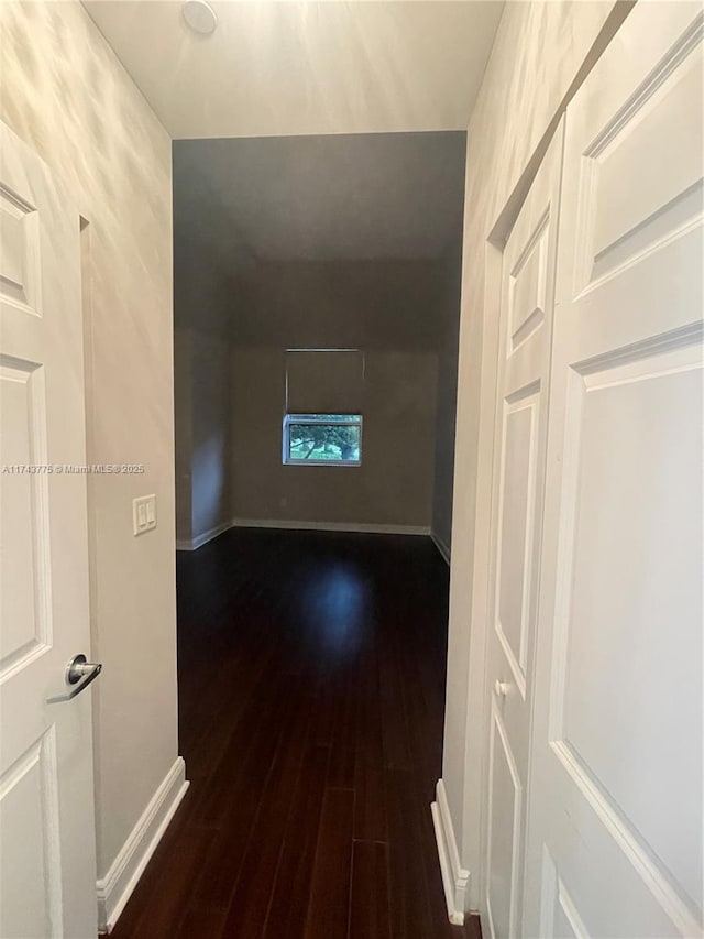 corridor with dark hardwood / wood-style flooring