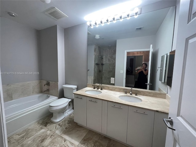 full bathroom featuring vanity, separate shower and tub, and toilet