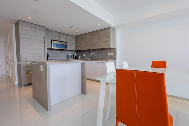 kitchen with a center island, sink, decorative backsplash, and white cabinets