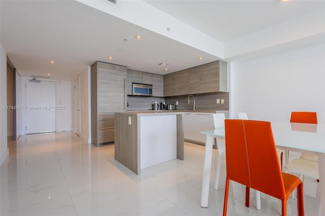 kitchen with tasteful backsplash, a center island, and a kitchen bar