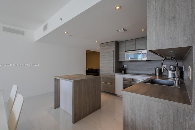 kitchen with stainless steel appliances, tasteful backsplash, and sink