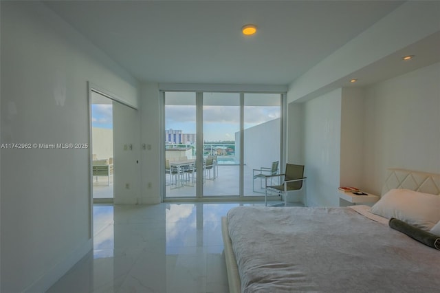 bedroom with expansive windows and access to exterior