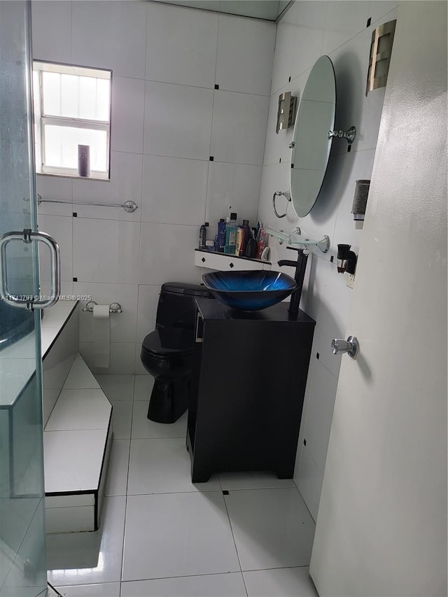 bathroom with vanity, tile walls, tile patterned floors, and toilet