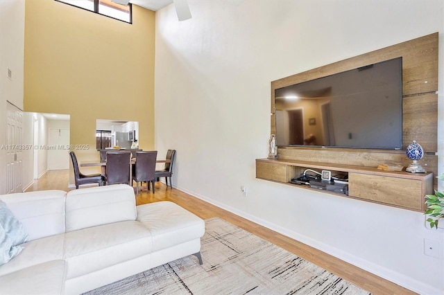 living room with hardwood / wood-style floors and a towering ceiling