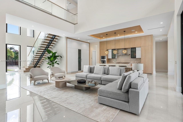 living room with a towering ceiling and a raised ceiling