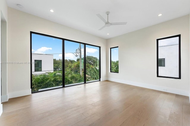 empty room with ceiling fan and light hardwood / wood-style flooring