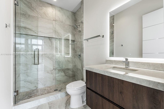 bathroom with vanity, a shower with door, and toilet