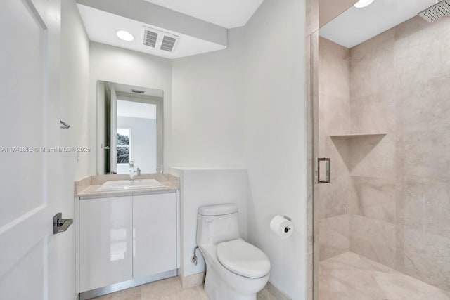 bathroom featuring vanity, a shower with shower door, and toilet