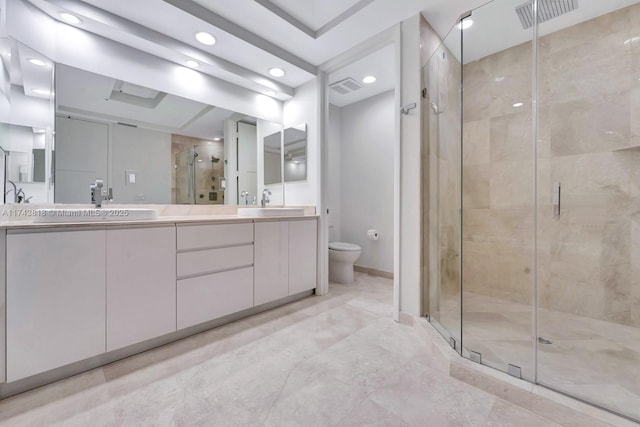 bathroom featuring vanity, toilet, and a shower with shower door