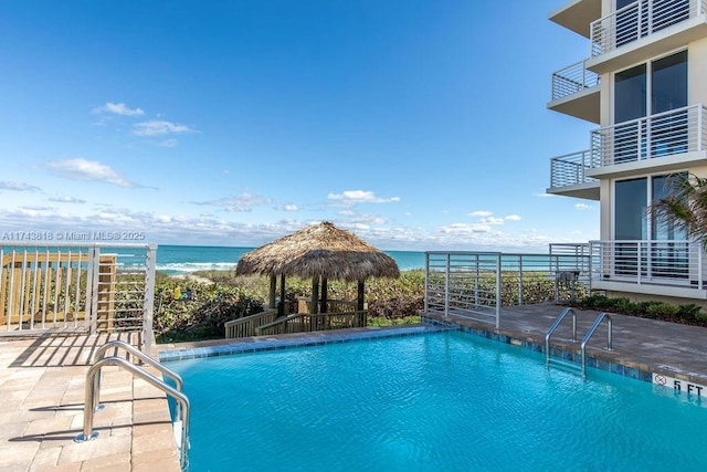 view of swimming pool featuring a gazebo, a water view, and a patio