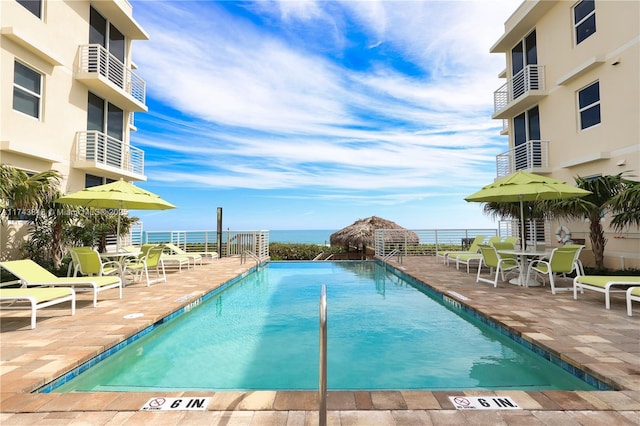 community pool featuring a patio and a water view