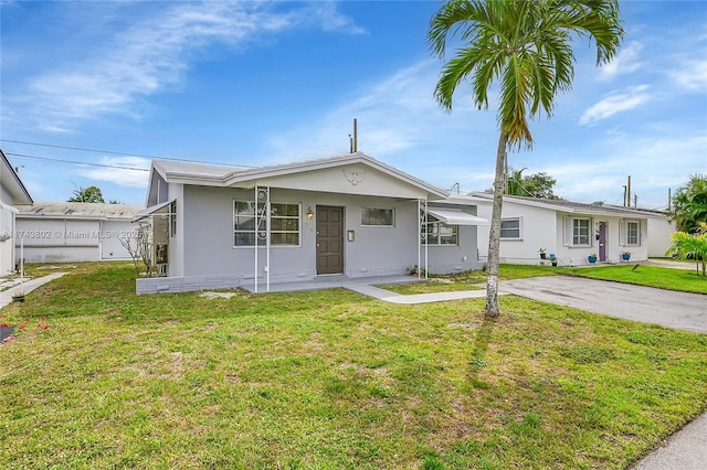 view of front of property with driveway, a front lawn, and stucco siding