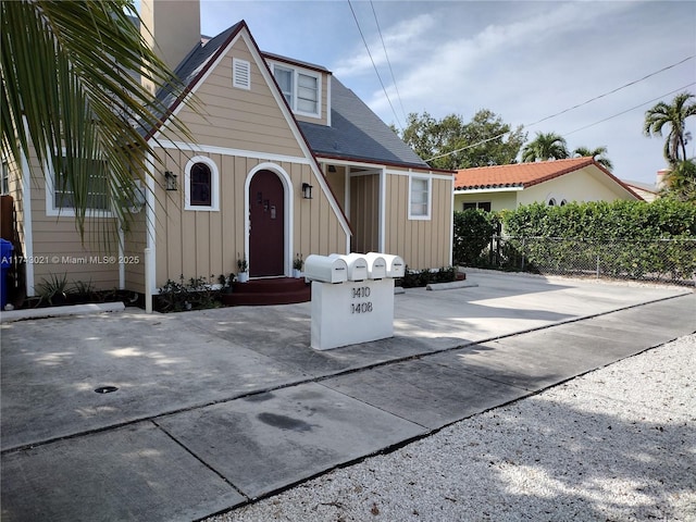 view of front of house featuring board and batten siding, a patio area, and fence