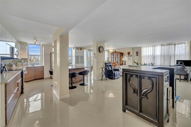 kitchen featuring light tile patterned floors, stainless steel appliances, and a kitchen island