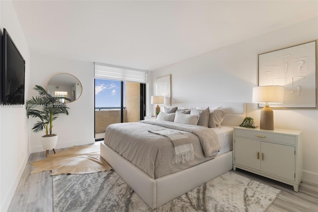 bedroom with access to outside and light wood-type flooring