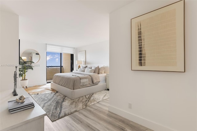 bedroom with access to exterior and light wood-type flooring