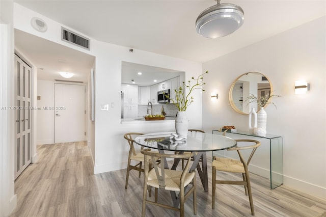 dining space with light wood-type flooring