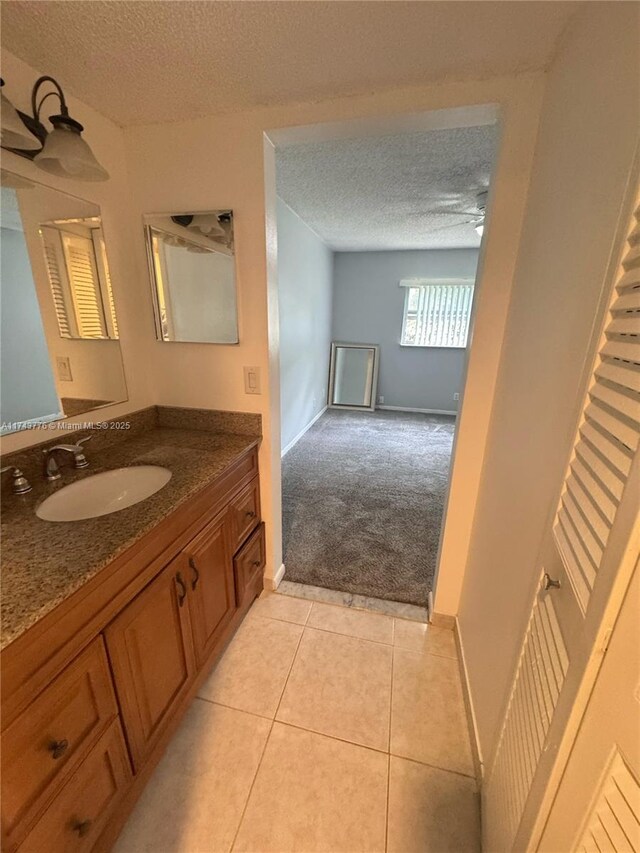 5155 E Sabal Palm Blvd Unit 204, Tamarac, FL 33319 - bathroom with baseboards, tile patterned floors, vanity, and a textured ceiling