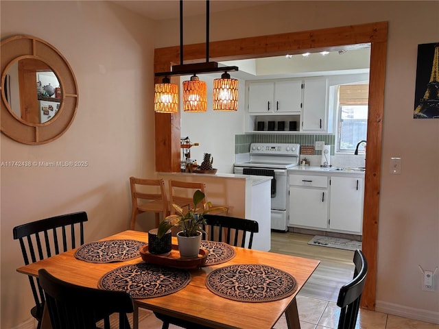 dining space featuring sink and light tile patterned floors