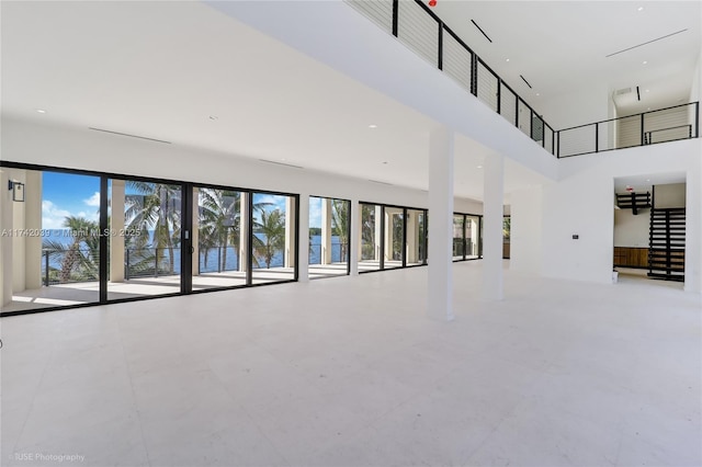 unfurnished living room with a towering ceiling