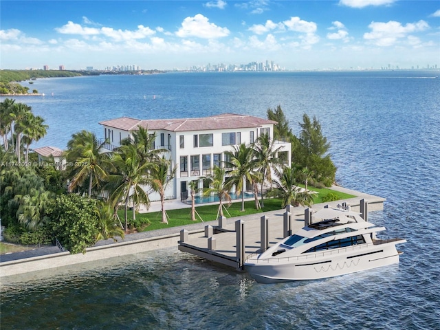 dock area featuring a swimming pool, a balcony, and a water view