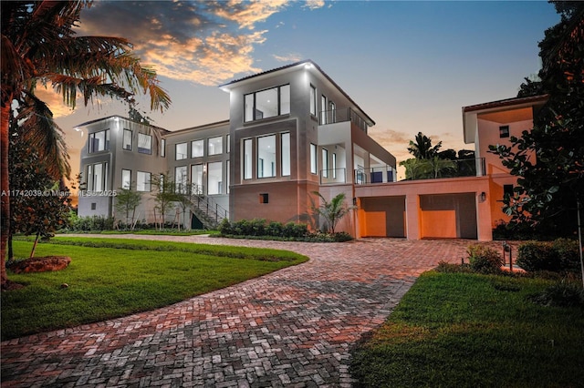 650 Lugo Ave, Coral Gables, FL 33156 - contemporary home with stucco siding, decorative driveway, a yard, and a balcony