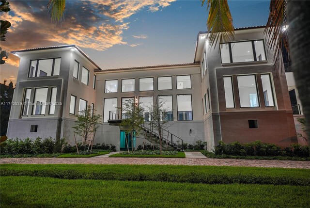 650 Lugo Ave, Coral Gables, FL 33156 - rear view of house featuring a yard, a tile roof, and stucco siding