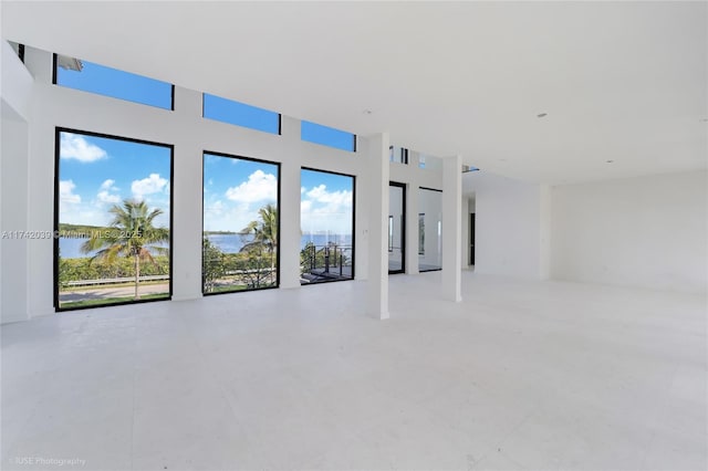 650 Lugo Ave, Coral Gables, FL 33156 - unfurnished living room featuring a healthy amount of sunlight, a towering ceiling, and a water view