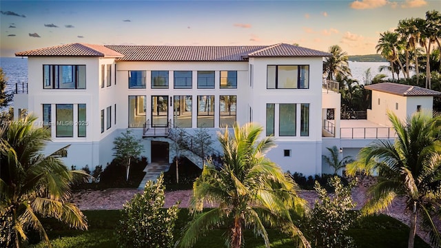 650 Lugo Ave, Coral Gables, FL 33156 - back of property featuring a water view, a balcony, a tiled roof, and stucco siding