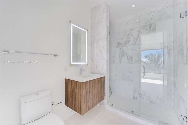 full bathroom with a marble finish shower, toilet, and vanity