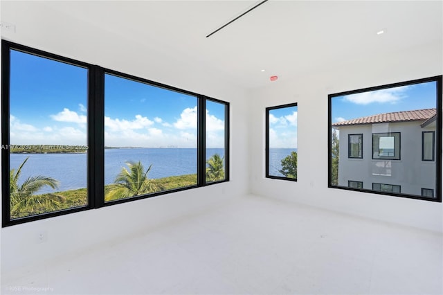 unfurnished sunroom featuring a water view