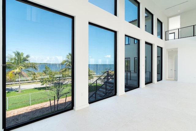 interior space featuring a high ceiling and a water view