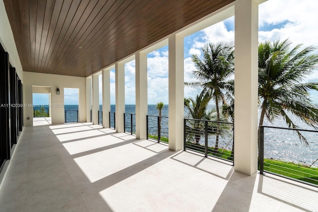 view of patio with a balcony and a water view