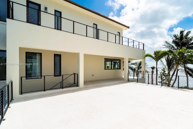 back of property with a patio, a balcony, and stucco siding