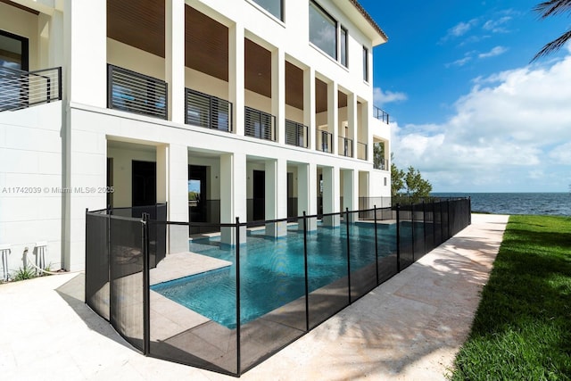 view of pool with a fenced in pool, a water view, and a patio area