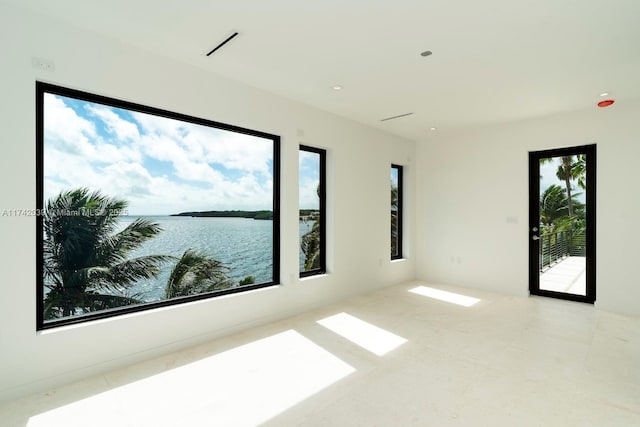 unfurnished room with visible vents and a water view