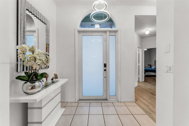 foyer entrance with light tile patterned floors and a textured ceiling