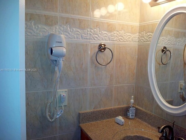 bathroom with vanity and tile walls