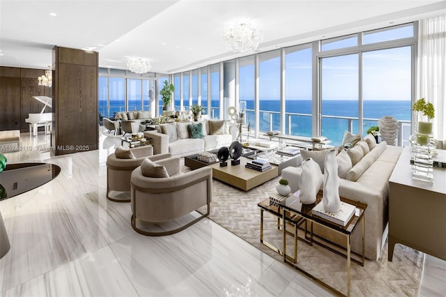 living room featuring expansive windows, a chandelier, and a water view