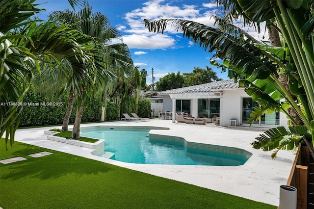 pool with outdoor lounge area, a patio area, a lawn, and a pergola