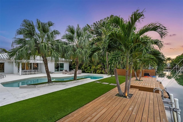 outdoor pool featuring a lawn, a patio area, an outdoor hangout area, and a wooden deck