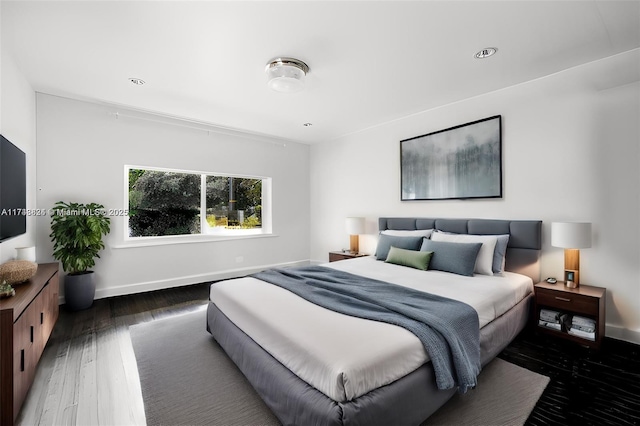 bedroom with baseboards and wood finished floors